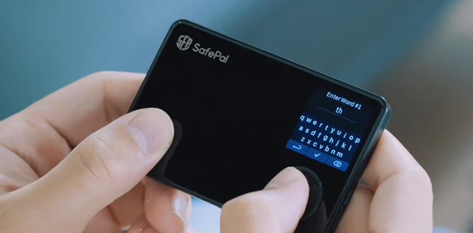 A close-up of hands holding a SafePal crypto hardware wallet, with the device's screen displaying a QWERTY keyboard prompting to "Enter Word #1" for seed phrase entry. The image visually represents the SafePal brand mentioned in the accompanying post about the data leak affecting nearly 40,000 customers.
