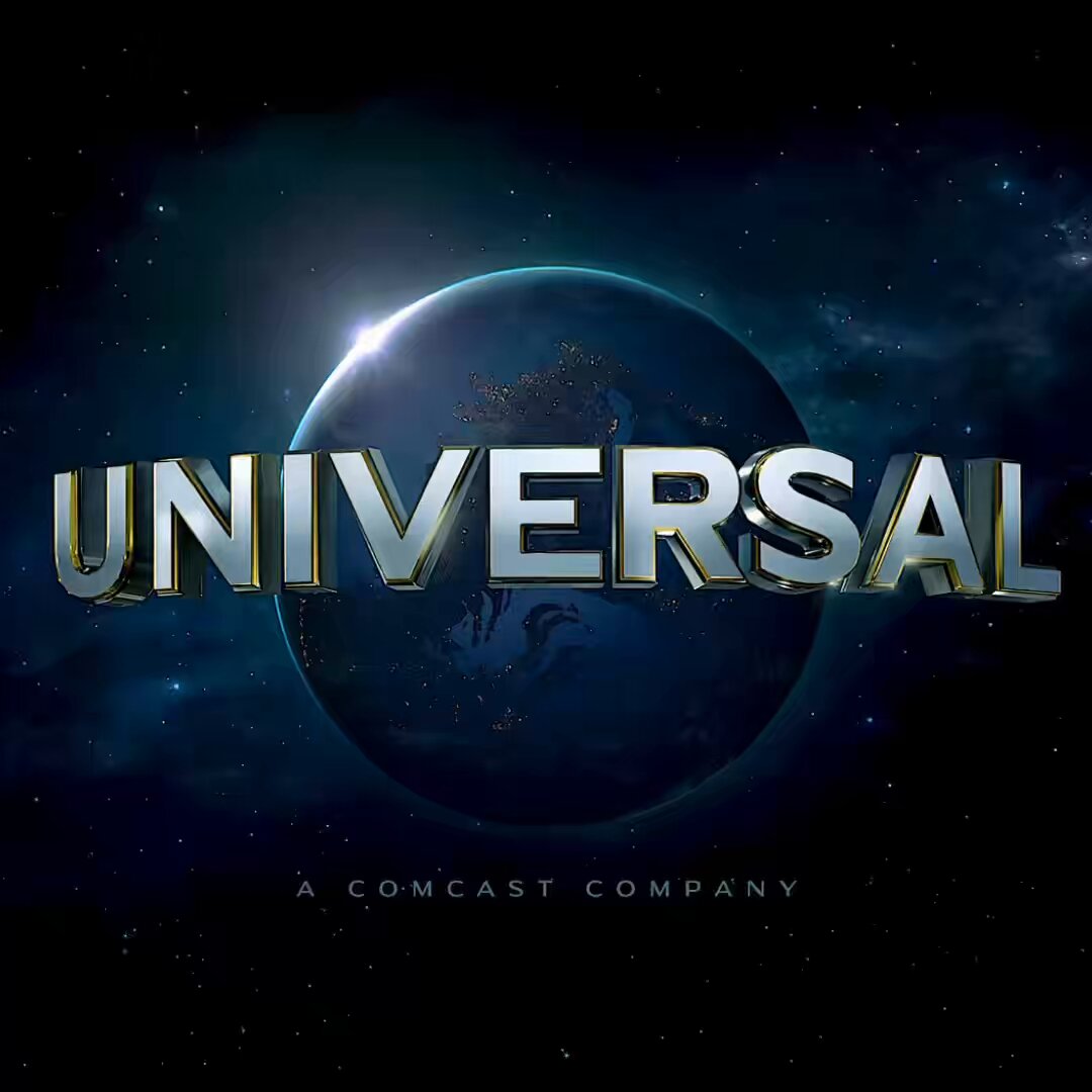 The image features a logo for Universal Studios, which is a large blue planet with gold lettering that reads "Universal" at the top of the frame. The background of the image is dark blue, creating a contrast between the logo and its surroundings. Below the logo, there's text that says "A COMCAST COMPANY". This suggests that the image might be related to an event or promotion for Universal Studios, possibly as part of their NFT collection.
