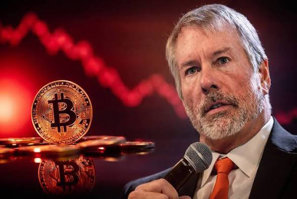 This image shows Michael Saylor with a Bitcoin symbol and a red downward trending graph in the background, alluding to the post's theory about Bitcoin's price and Saylor's holdings.