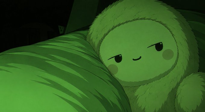 A green, furry, plush-like animated character with a smiling face lies tucked under a green blanket in a dimly lit room.