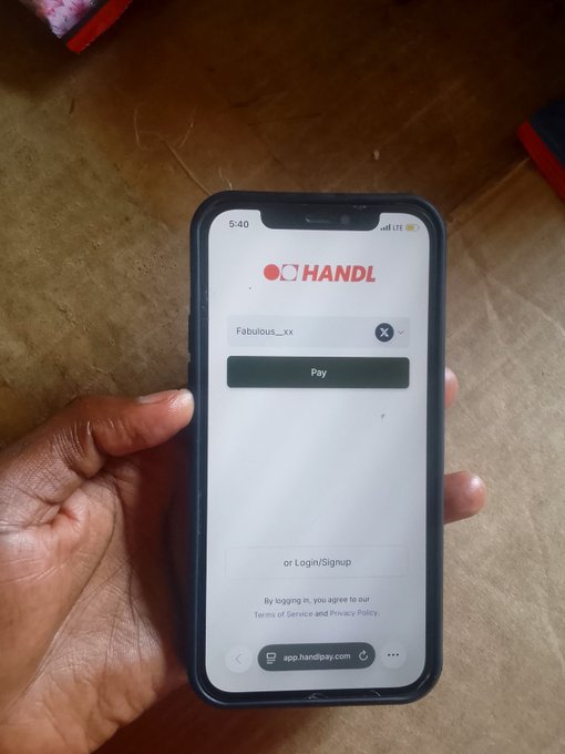 A hand holds a smartphone displaying the HANDL payment app's login screen, where only a username ("Fabulous__xx") is entered to proceed—no wallet or bank details required, illustrating the seamless payment experience referenced in the caption.