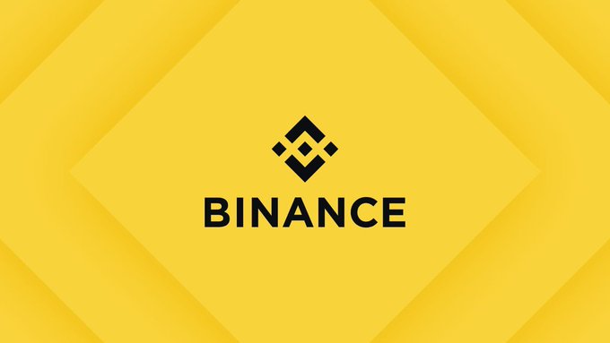The image displays the Binance logo and wordmark in black against a layered yellow geometric background. It serves as a visual representation of the cryptocurrency exchange involved in the ongoing $473 million legal dispute with RedotPay over allegedly diverted users.