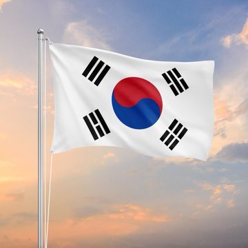 The South Korean flag waves against a sunset sky, symbolizing the nation as it prepares to roll out new crypto asset seizure regulations effective October 1st.