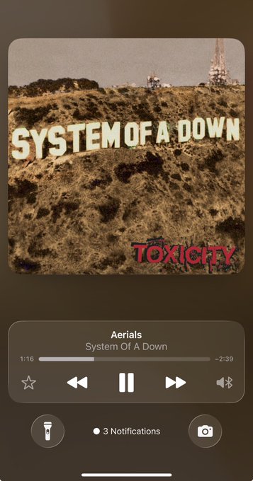 iPhone music player displaying System of a Down's "Aerials" from the Toxicity album, with the album art showing a hillside scene.