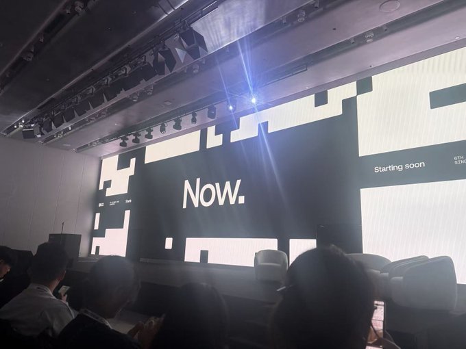 An audience sits in a dimly lit auditorium facing a large screen displaying 'NOW.' in white text, with 'Starting soon' and the ETHGlobal logo visible on the right side.