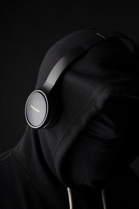 A figure draped in a black hoodie wears Panasonic over-ear headphones, with the brand name visible on the ear cup. The image complements the post's message about healthy sleep habits by visually emphasizing rest and the tools—like headphones—that help facilitate a calming nighttime routine.