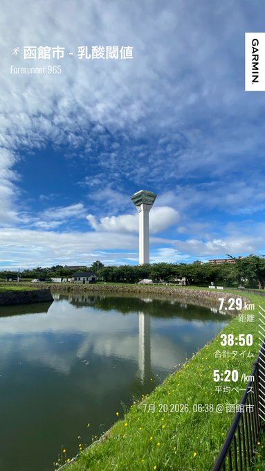 Garmin running app screenshot taken in Hakodate City (函館市) showing a 7.29 km run with a lactic threshold marker, 38:50 total time, 5:20/km average pace on July 20, 2026, featuring a scenic view of a tall observation tower reflected in a pond under a cloudy blue sky.
