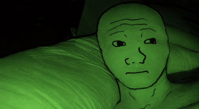 A digitally drawn, 'Wojak'-style green face meme with a stoic expression, set against a green-tinted bedroom background.