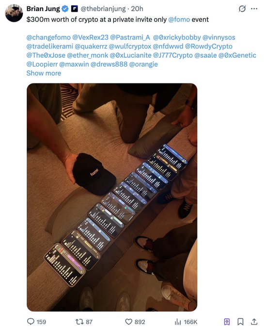 The image shows a row of smartphones lined up on the floor displaying crypto trading charts, with a person holding a "Frog" branded cap nearby, at a private FOMO event reportedly involving $300M worth of crypto. The accompanying post warns that bringing phones holding significant crypto assets to such events poses security risks from NFC taps, WiFi vulnerabilities, and potential bad actors.