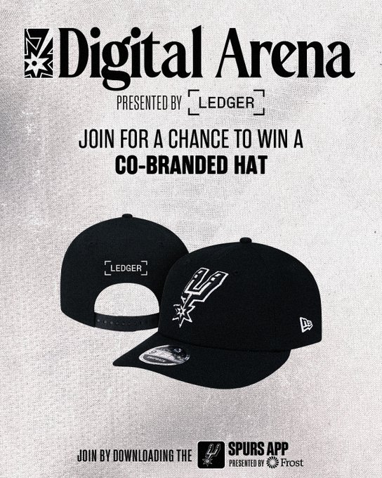 The image features two black hats, one of which has a logo that says "Spurs App" on it. The text in the image suggests that there's an ongoing contest or promotion related to the digital arena, where people can join by sharing the post with their friends and family. This could be for a chance to win a sponsored hat, such as the one displayed in the image.