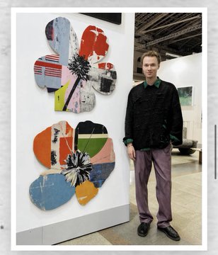 A man in a black jacket and gray pants stands next to a large, colorful abstract artwork composed of fragmented pieces arranged in flower-like forms, displayed at what appears to be an art gallery or exhibition space. The image relates to the post as it showcases the founder, Jeny Avyguzov, alongside an example of the unique fragment-style floral art featured in his "Fragment of Growth" NFT collection.