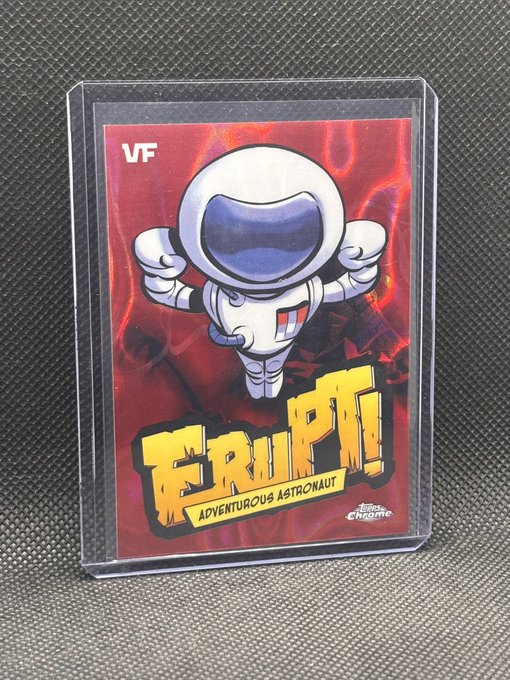 A collectible trading card featuring the "Adventurous Astronaut" character from the "FRUPT!" series is displayed in a protective case, labeled "VF" in the top left corner with VeeFriends branding at the bottom. The card showcases a cartoon astronaut in a classic Topps design, representing a pull from a VeeFriends hobby pack.