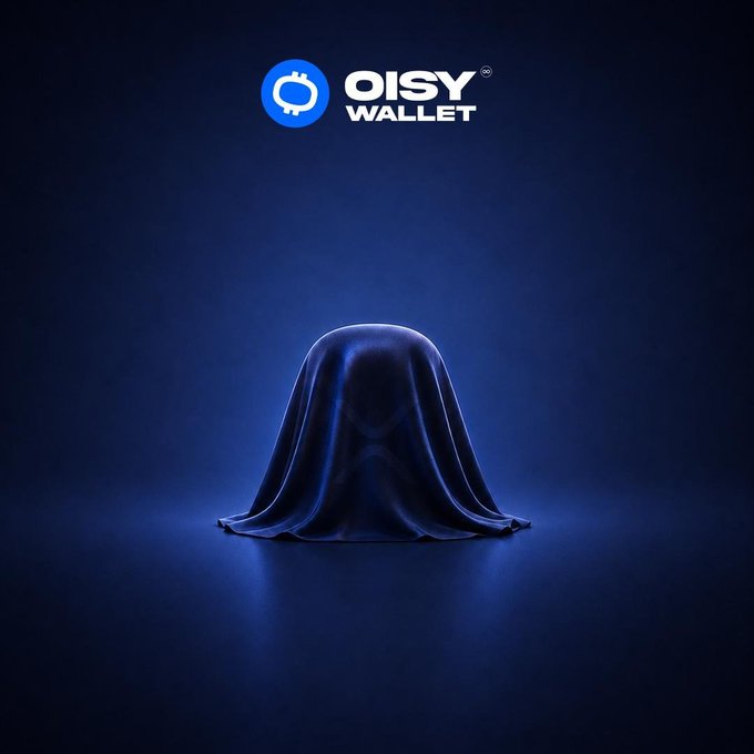 A teaser image featuring the OISY WALLET logo at the top, with a dark blue cloth-draped object sitting on a reflective surface against a dark blue background.