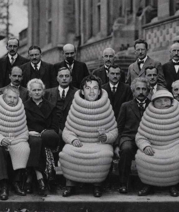 A humorous, edited black-and-white vintage photograph of a group of formally dressed people, where several individuals are absurdly encased in the coiled, ribbed bodies of Michelin Man-like figures.