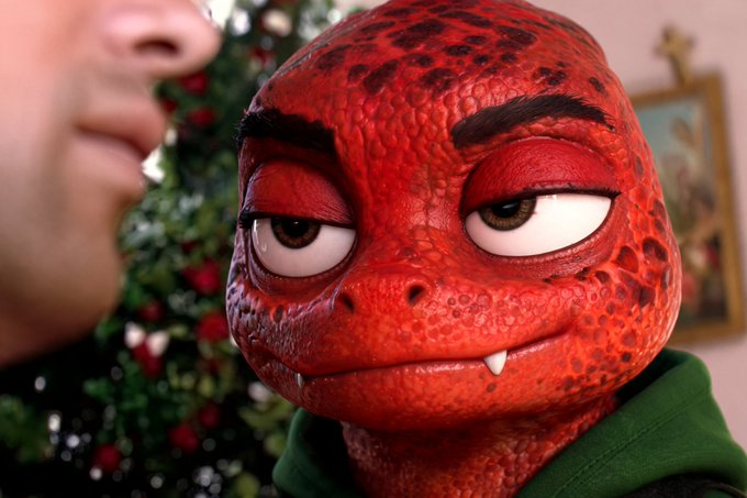 A red, scaly humanoid creature with horns and fangs stares intently at a person's face, set against a festive Christmas tree background, humorously casting the demonic figure as a quirky new holiday intern.