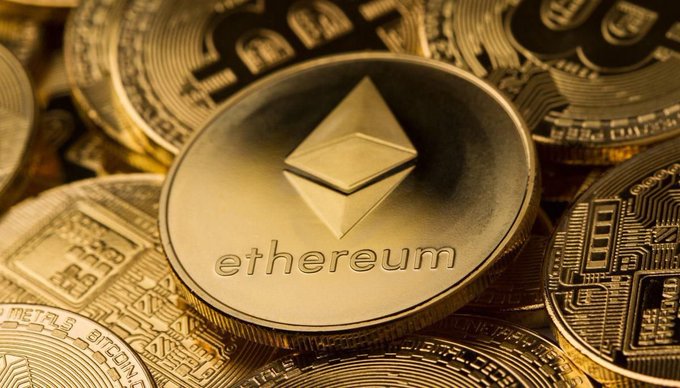 A golden Ethereum coin featuring its diamond-shaped logo and the word "ethereum" is prominently displayed atop a pile of other cryptocurrency coins, visually representing the $ETH staking dynamics highlighted in the WSX News update.