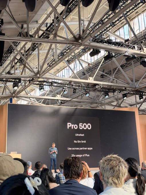 A presenter stands on stage at a tech conference in front of a large screen displaying 'Pro 500' with bullet points including 'Ultrafast', 'No 5h limit', 'Use across partner apps', and '25x usage of Plus'.