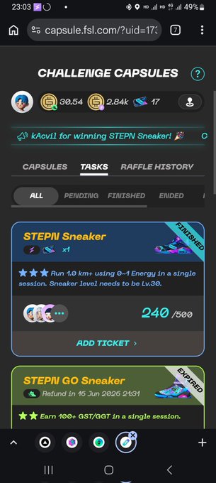 The image shows a cell phone screen displaying a list of items, including a "Challenge Capsules" tab with various game options. The text on the screen reads "#STEPN 0-1チャレンジでけたー！散々電波障害でセッション切れまにしようと一度諦めてスロージョグ1時間、からの一か八かせずけることがあるときにおいて", which suggests that the user is looking at a list of games to play on their phone.