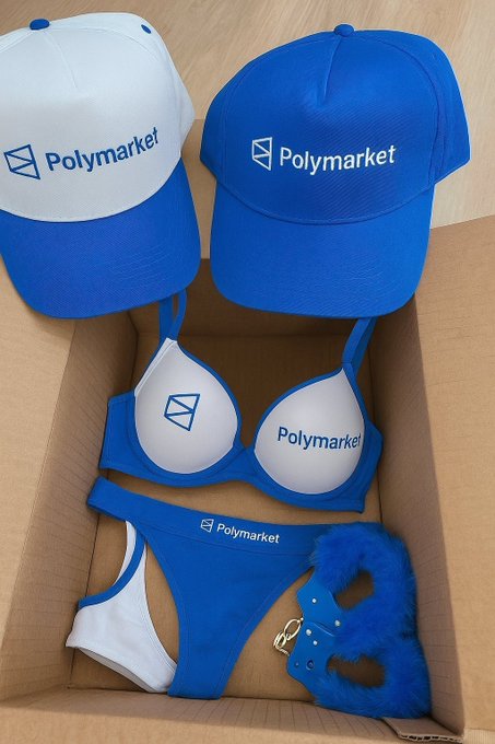 A box containing promotional merchandise featuring the Polymarket logo, including two caps, a bikini, and a furry blue accessory.
