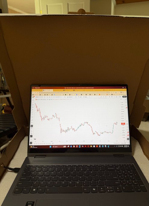 A laptop displays a TradingView chart titled "Bitcoin Bull Market 2018 vs Current," showing Bitcoin's price action with a notable downtrend, propped up inside a large pizza box—visually reinforcing the post's joke about being told to stop watching Bitcoin and hiding it by staring at a pizza box instead.
