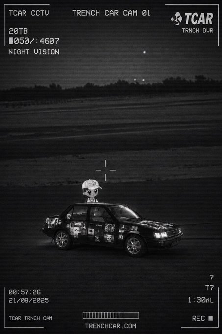 A night vision surveillance camera image showing a figure standing on top of a race car on a track, with text including 'TCAR CCTV', 'TRENCH CAR CAM 01', '21/08/2025', and 'TRENCHCAR.COM'.