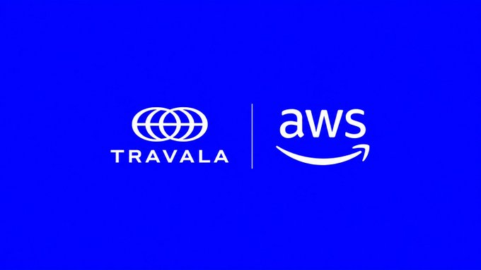 A blue graphic displays the white logos of Travala and AWS side by side, separated by a thin vertical line, indicating a partnership between the two companies.