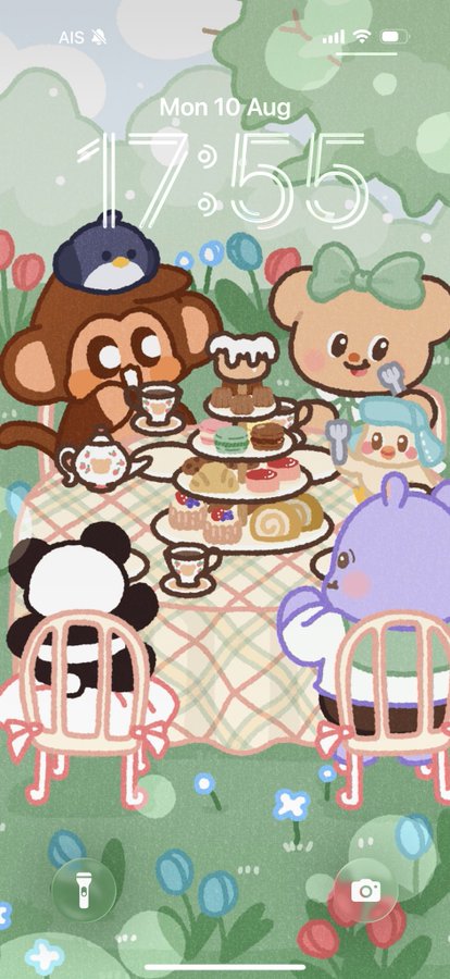 A phone lock screen displaying a cute illustrated tea party with animal characters around a tiered tray of desserts, showing the date "Mon 10 Aug" and time "17:55".