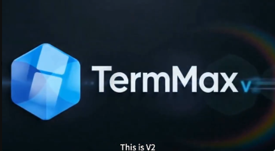 The image features a logo for a software called "TermMax V2" with a blue hexagon at its center, which is the main focus of the image. The background of the image is black, making the blue hexagon stand out prominently. The text "This is V2" is written in white letters below the hexagon, indicating that this is a new version or update of the software.