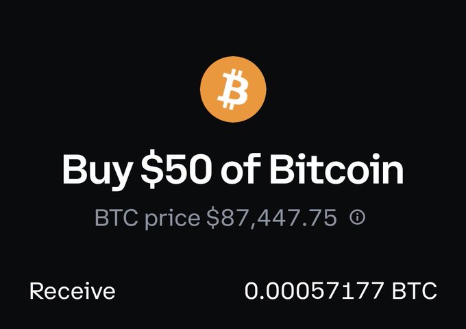 A Bitcoin purchase screen on Coinbase shows a $50 buy at a BTC price of $87,447.75, yielding only 0.00057177 BTC—roughly $950 above the actual spot price. This illustrates the user's complaint about Coinbase's hefty spread, as spot was around $86,500 while Coinbase was charging nearly $1,000 more per coin.