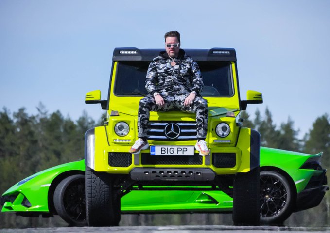 Elon Musk sits on the hood of a bright yellow Mercedes G-Wagon with a green sports car behind it; the license plate reads 'BIG PP'.