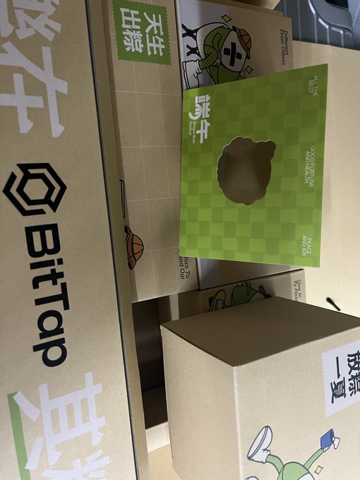 A collection of BitTap branded cardboard boxes with green checkered design and cartoon characters, featuring Chinese text labels.