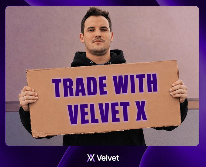 A promotional image showing a man holding a cardboard sign that reads 'TRADE WITH VELVET X' against a purple background with the Velvet logo.