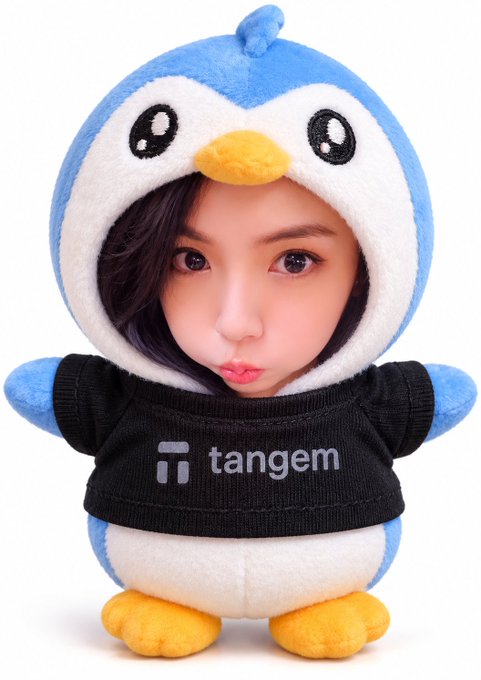 A person wearing a plush blue and white penguin costume with a black shirt displaying the 'Tangem' logo.
