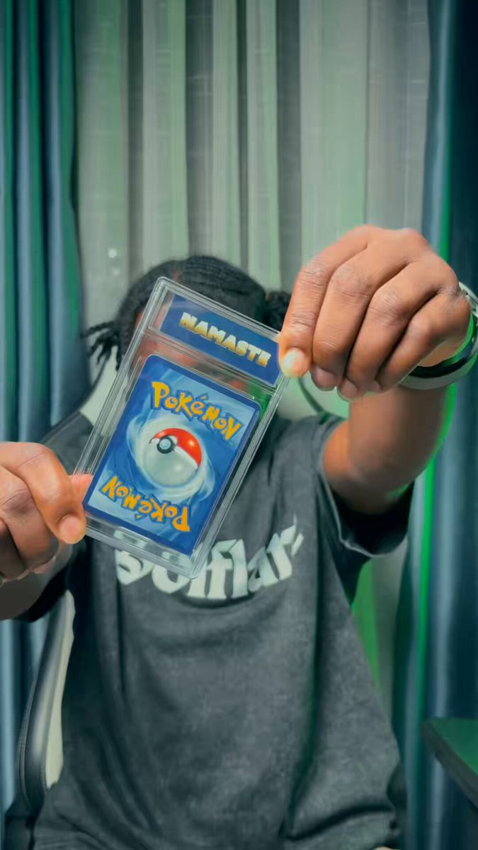 The image features a person holding up a Pokemon card, which has been ripped out of its original packaging and placed inside their wallet. This action suggests that they are excited about the card or have recently acquired it. The post includes text that reads "I just ripped my first @solflare Pack straight in the wallet and pulled this graded slab.. The in-wallet reveal hits different Who else ripping today? Drop your pulls". It seems like a lighthearted moment captured by someone who is enthusiastic about Pokemon cards, possibly sharing their excitement with others.

The person holding up the card has a casual style, as indicated by their grey t-shirt and black pants. The image also includes text that reads "Manafra", which could be a reference to the character Manaf from the Pokemon series or simply an unrelated name.