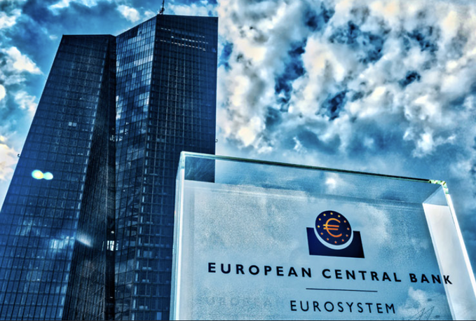 A glass sign for the "European Central Bank - Eurosystem" stands in the foreground with a tall skyscraper and dramatic cloudy sky in the background, visually reinforcing the article's claim about ECB leadership pushing for central bank money to migrate onto blockchain infrastructure.