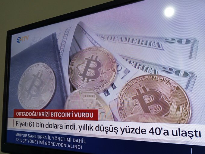 The image shows a television screen displaying various coins, including Bitcoins, along with some money notes. The text on the screen reads "Haberlere düşmüşüz şimdi herkes korkuyor ve daha düşük bekliyor ALIM ZAMANI BTC 59K eth 1.6K Bu fiyatları bu aylardaki son görüşümüz olacak." The coins and money notes are spread across the screen, with some of them overlapping each other. The image also includes a post that reads "Haberlere düşmüşüz şimdi herkes korkuyor ve daha düşük bekliyor ALIM ZAMANI BTC 59K eth 1.6K Bu fiyatları bu aylardaki son görüşümüz olacak."