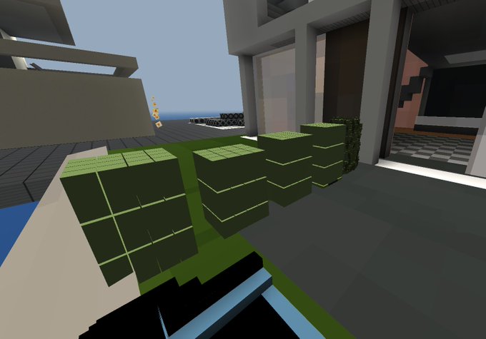 A Minecraft-style 3D rendered scene showing green block structures on a modern building rooftop with a view of the ocean in the background.
