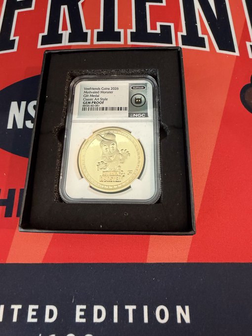 A graded gold coin in a black display box features a cartoon monster and text 'Veefriends Coins 2026 Motiverse! Monster', 'Classic Art Style GEM PROOF 100', and an NGC grading label.