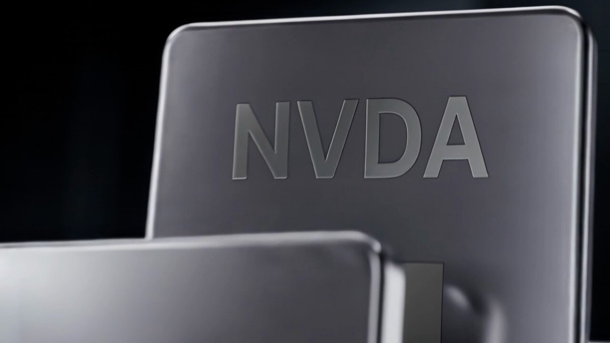 The image shows a close-up view of two laptops, both with the word "NVDA" written on their backs. The laptops are placed side by side against a black background, creating a striking contrast that highlights the laptops' presence. The text "Your all-in-one multi-asset trading destination is officially live" is also visible in the image, indicating that the laptops have been launched and are ready for use.