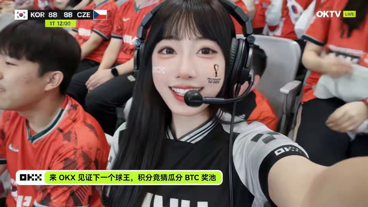 The image features a woman wearing headphones, sitting among other people who are also wearing headphones. She appears to be smiling for the camera while holding her headset up. The scene takes place at an event or gathering where attendees have their headphones on. A caption below the image reads "最近看很多球迷朋友们关注了我 感谢大家 世界杯期间", which suggests that the woman in the image is a popular figure or someone of interest to others at this event.