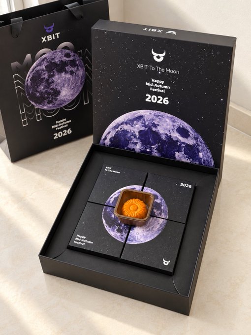 A black "XBIT To The Moon Happy Mid-Autumn Festival 2026" gift box containing a single golden mooncake sits beside a matching XBIT shopping bag, with the accompanying post thanking XBIT (@XBITDEX_ZH) and Little Golden Treasure (@alphaxiaojinbao) for the festive moon-themed crypto gift.