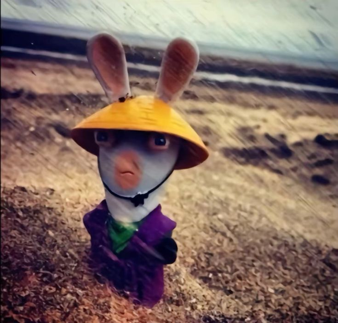 A surreal figure with rabbit ears and a human-like face wears a yellow wizard-style hat and purple robe, standing in a barren landscape with a stylized, vintage filter applied. The image humorously embodies the "wizard" meme referenced in the post, playfully tying into the magical, creative crypto culture of the $MIM ecosystem and its spellcasting community.