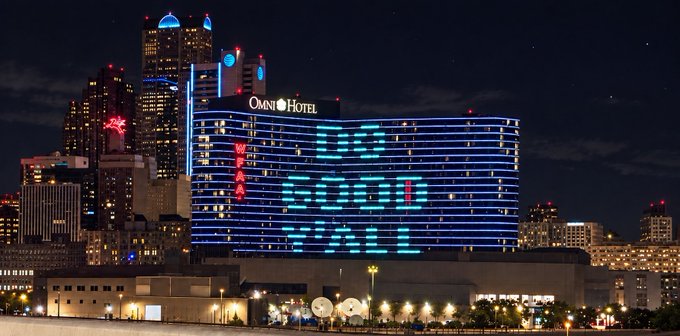 A nighttime cityscape of Atlantic City featuring the brightly illuminated Omni Hotel and Ocean Casino Resort, with blue neon lighting and an "Omni Hotel" sign visible against the dark sky.