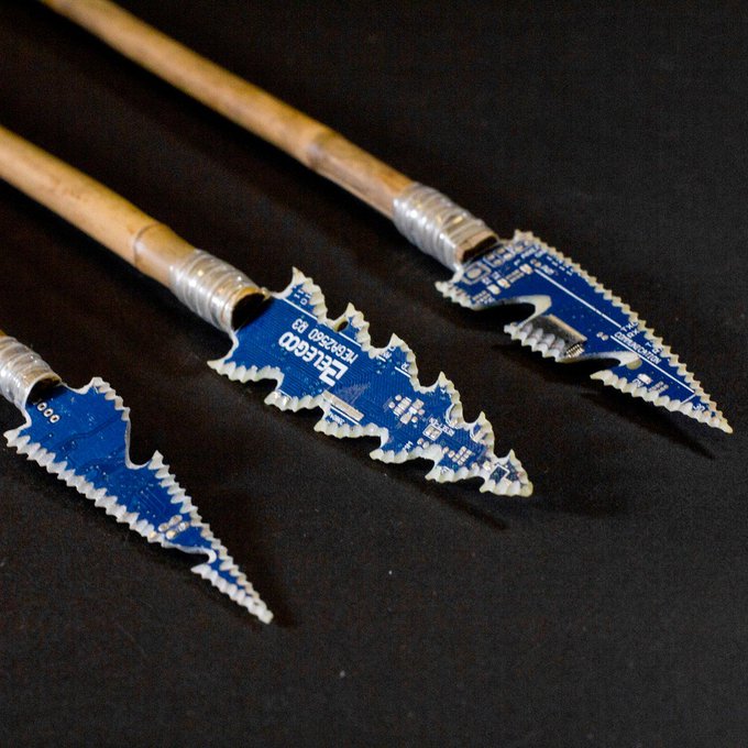 Three spear tips crafted from blue circuit boards attached to wooden shafts, with visible text reading 'ELEGOO' and 'E8599.01'.