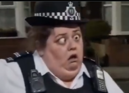 A police officer wearing a black and white checkered hat and a uniform with a radio displays a shocked, wide-eyed expression.