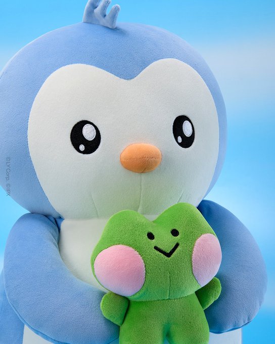 A plush toy of a blue penguin holding a smaller green frog-like character against a light blue background, with a small 'Liyuu & IIPY' watermark visible.