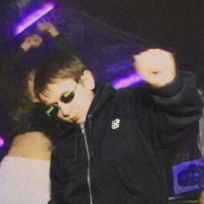The image features a young boy wearing sunglasses, a black hoodie with white text, and his arms raised high above his head. He appears to be dancing or having fun at an event. The background of the photo shows a purple light strip, which could suggest that they are in a club or a similar venue where such lighting is common.

The post "Apes Are Vibing" seems to be related to this image as it uses the boy's pose and attire to convey a sense of fun and enjoyment typically associated with parties or social gatherings. The caption might be interpreted as an invitation for others to join in on the party vibe, emphasizing the energetic atmosphere created by the young boy's actions.