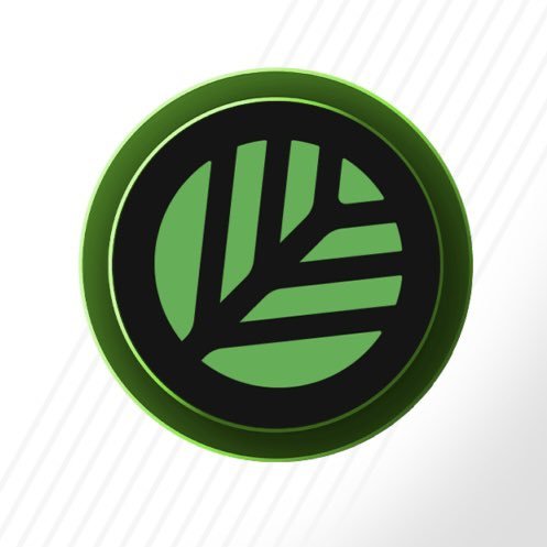 A green and black circular logo featuring a stylized tree design within a glossy button-like emblem on a white background.