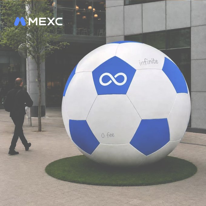A giant blue and white soccer ball sits on artificial grass, featuring the MEXC logo, an infinity symbol, and the words "infinite" and "0 fee," with a man in a black jacket walking past it. The oversized ball ties into the post's "sign your message" theme, inviting the community to leave their own mark—much like MEXC's signature "0 fee" pledge.