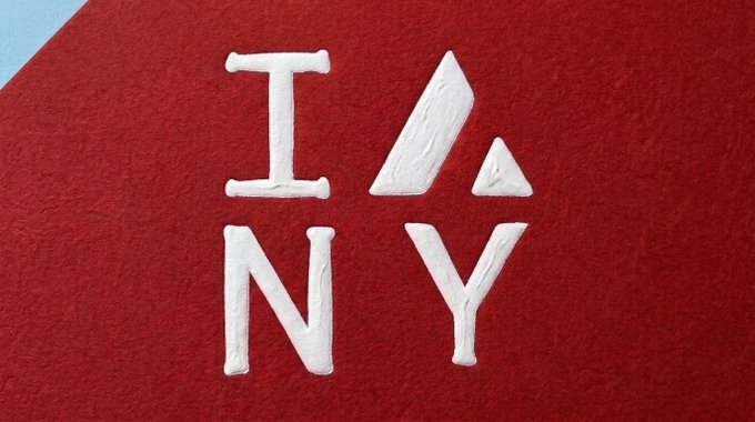 The I ❤️ NY logo made from white textured material on a red felt-like background.